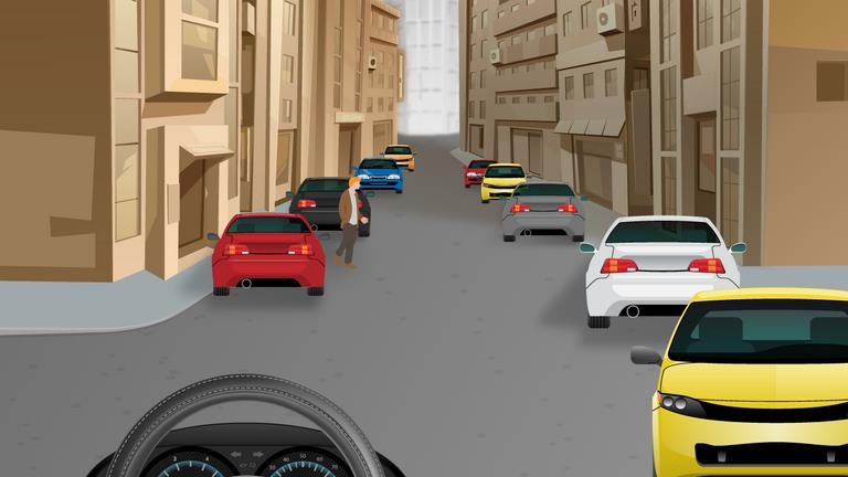 Narrow street lined with buildings and parked cars on both sides; a yellow car faces the viewer on the right.