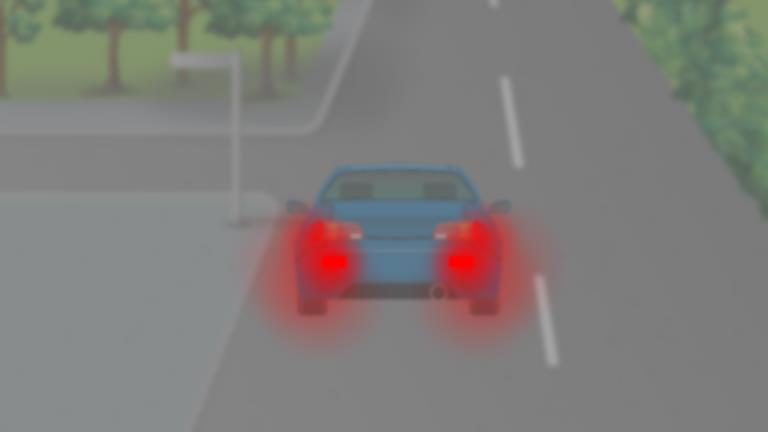 Hazy view of a car ahead with two bright red rear lights.