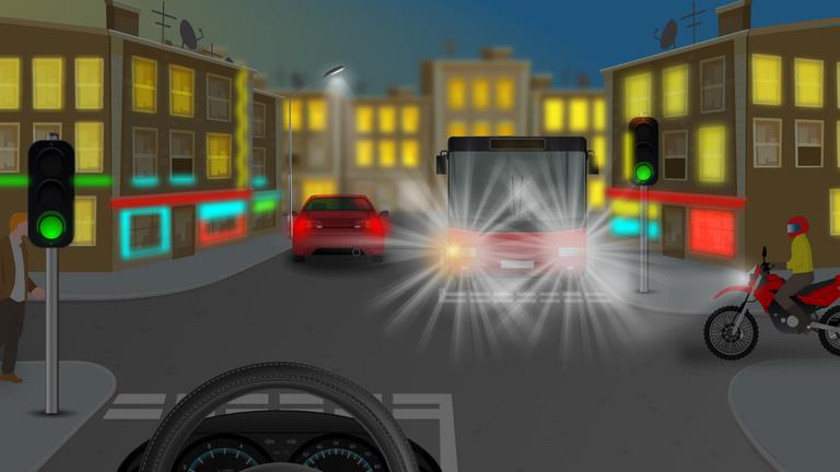 Night-time city junction with a car ahead, bright headlights opposite and a motorcyclist on the right.