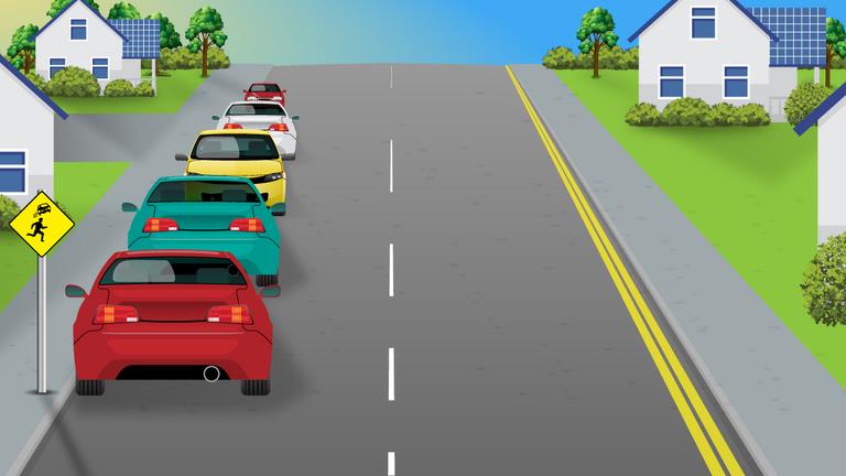 Residential road with several cars queued along the left and two parallel yellow lines along the right edge.