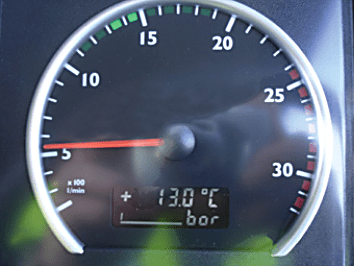 Photograph of a circular numbered dashboard gauge, with the needle near 5 and a small digital display below.