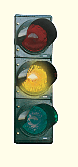 Vertical traffic light with the middle amber lamp illuminated.
